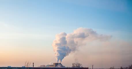 White thick smoke from the boiler room chimney. Industrial zone.