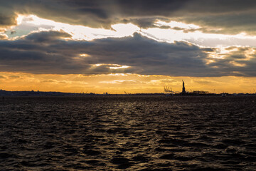 Fototapeta na wymiar A Beautiful Sunset Looking the Statue of Liberty