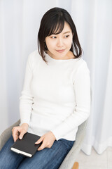 Woman sitting in a chair and holding a book