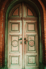 vintage antique doors of ancient building with erased green and pink paint