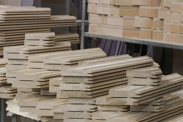 solid wood oak parts are stacked on a rack in the carpentry shop close up without people