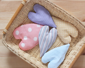 rag hearts in a basket on the table, top view.