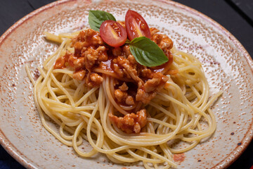 Fried spaghetti with chicken sauce in black background plate