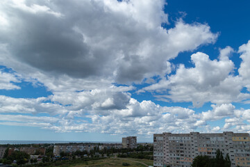 Fluffy white clouds hung over the city very low.