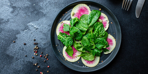 Watermelon radish salad chinese daikon diet vegan Slices pink fruit vegetables, green leaves spinach lettuce vegetarian meal snack top view copy space food background rustic keto or paleo diet