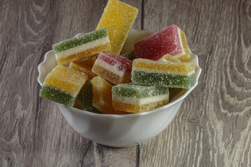 Multi colored layered marmalade in a dish. Closeup of wonderful dessert.