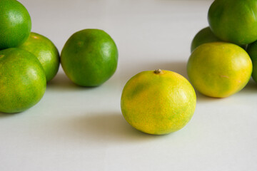 Green tangerines on white background