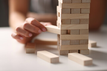Female hand taking out block from wooden tower closeup