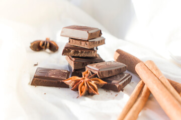 Dark and milk chocolate, cinnamon, anise star, brown sugar, marshmallow, meringue and milk over light background. Ingredients for making hot chocolate. Top view.