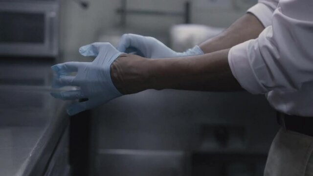 Manos de un trabajador poniendose guantes de latex