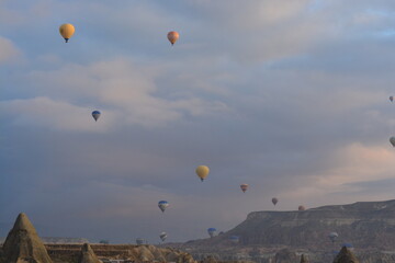 Tourist hot air balloons floating in the cloudy sky in Cappadocia. Cloudy weather. Colorful balloons.