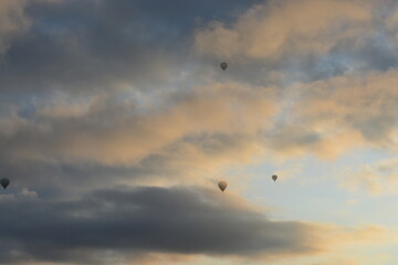 Tourist hot air balloons floating in the cloudy sky in Cappadocia. Cloudy weather. Colorful balloons.