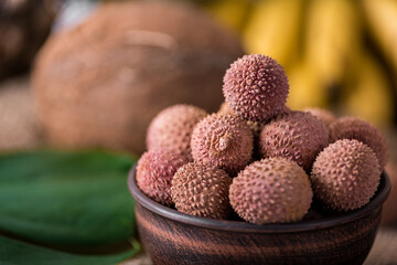 fresh organic lychee fruit on bamboo basket and old wood background, Blurred background selective focus