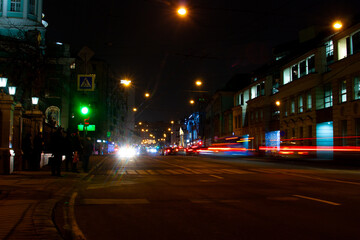 Fototapeta na wymiar Night street with traffic lights, shops and cars