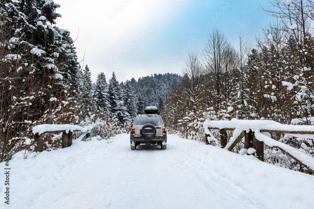 Wall mural off road adventure in winter snow covered wilderness forest. 4x4 icy road driving - Wall murals