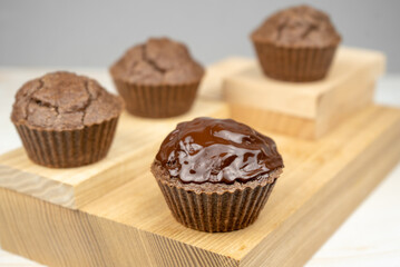 Brown chocolate muffins on wooden board