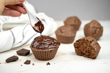 Homemade chocolate brown muffins on white table