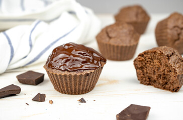 Homemade chocolate brown muffins on white table