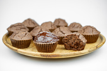 Set of homemade chocolate brown muffins on a wooden plate