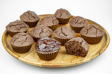 Set of homemade chocolate brown muffins on a wooden plate
