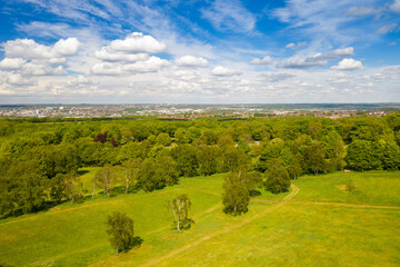 Aerial photo of the city of Leeds viewed from the village of Middleton and Middleton Park on a sunny day with white clouds in the sky and a lot of green trees in the summer time