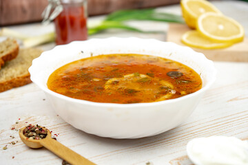 Traditional russian soup solyanka. Hodgepodge soup with meat, lemon and olives. Served with sour...