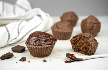 Homemade chocolate brown muffins on white table
