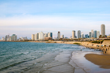 Summer day in sunny Jaffa with panoramic landscape view to new high buildings of Tel Aviv. Modern architecture on the seaside of Tel Aviv downtown on sunny day with blue sky background.