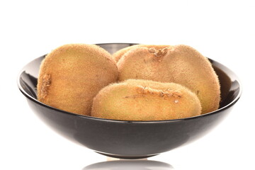 Several juicy organic kiwis in a black ceramic plate, close-up, isolated on white.