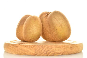 Two ripe organic kiwis on a round wooden tray, close up, isolated on white.