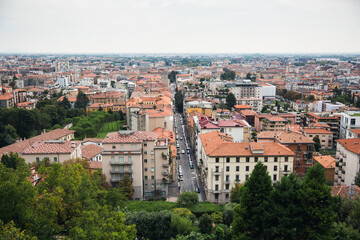 Fototapeta na wymiar Top view of houses, roofs, road and streets of old Italian city. City panorama, tourism.