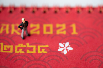 Miniature people : A traveler with a camera standing on the red background
