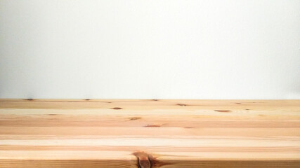 Empty wooden floor shelf in front of white old stucco wall with copy space.