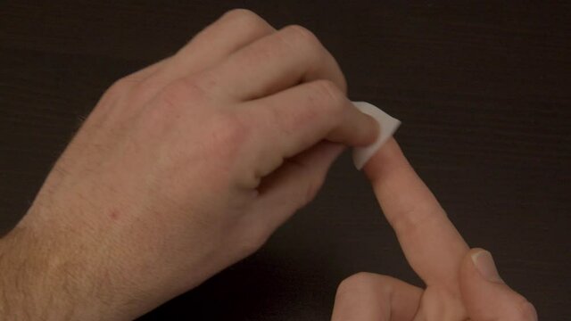 Finger being cleaned with alcohol swab in preparation of Covid-19 self test