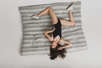 Free fall. Top view beautiful young woman's on striped mattress background. Having fun, happy, full...