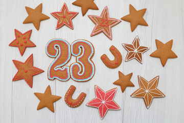 Gingerbreads in the form of stars and number "23" on Defender of the Fatherland Day on wooden background, copy space