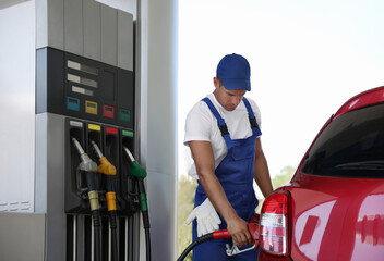 Fototapeta premium Worker refueling car at modern gas station
