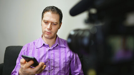 Man making video blog about mobile phones.
