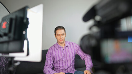 Handsome man recording his videoblog at home.