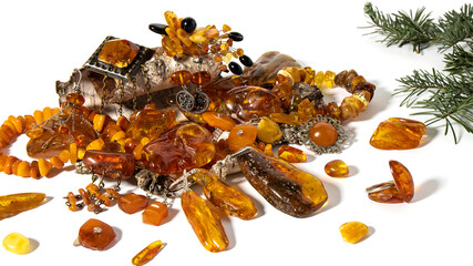 Lots of amazing old Baltic amber jewelry and amber stones on a birch bark on a white background.