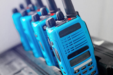A set of blue walkie-talkies stand in a row. The concept of readiness for a rescue operation or the transmission of a stable radio communication over a distance. Copy space
