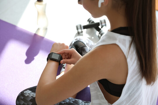 Woman checking fitness tracker in gym, closeup