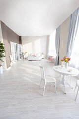 Luxurious and expensive interior of an open-plan apartment in light colors. Stylish modern bedroom with minimal design, dining area and guest space.