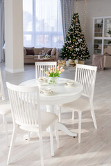 Luxury rich expensive apartment interior in light colors. Stylish contemporary minimalistic design. Full of sun light. A lot of space decorated with Christmas tree
