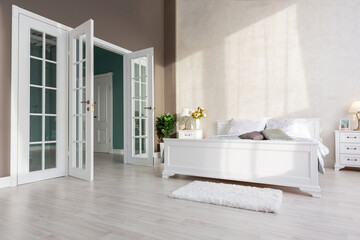 Stylish modern bedroom with a minimalistic design in a luxurious rich, expensive interior of an open-plan apartment in light colors.