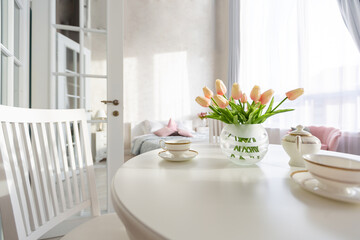Luxurious and expensive interior of an open-plan apartment in light colors. Stylish modern bedroom with minimal design, dining area and guest space.