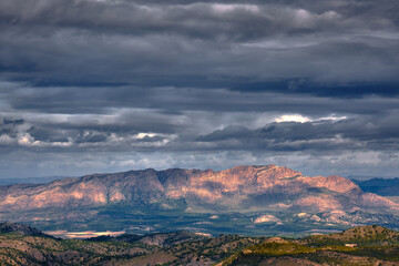 Fototapeta premium Dramatic and stormy sky over the mountains generating lights and shadows all over the horizon