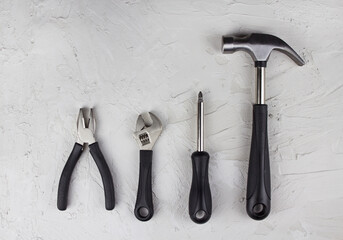 Construction tools, hammer, pliers, wrench, screwdriver flat lay on concrete background  - obrazy, fototapety, plakaty