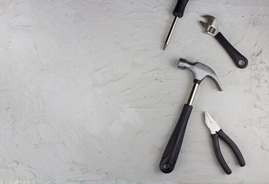 Construction tools, hammer, pliers, wrench, screwdriver flat lay on concrete background 