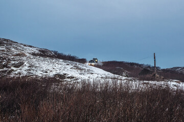 The car is on the move on a difficult icy road. Slippery Arctic road through the hills. Winter Teriberka.